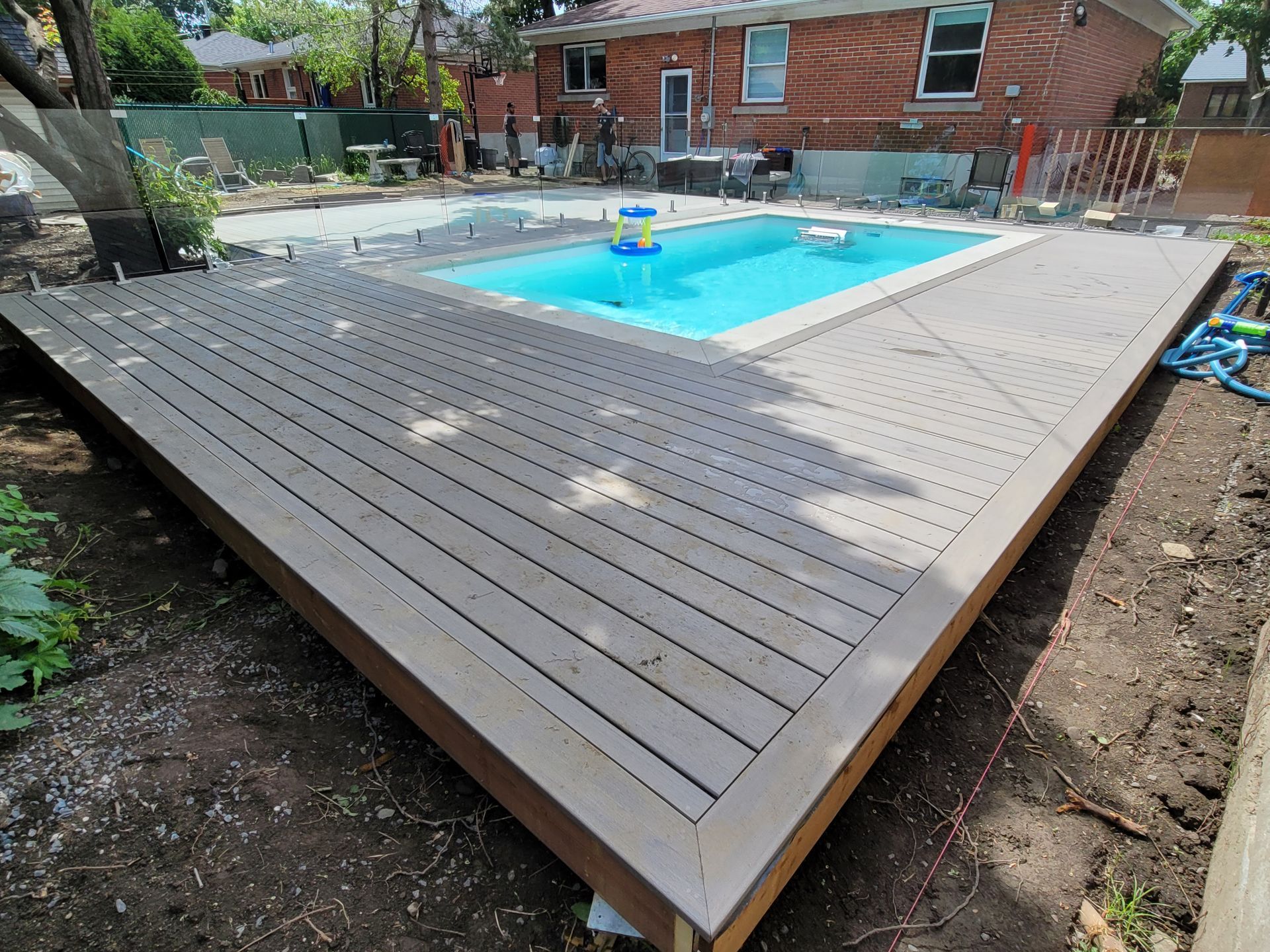 Une grande piscine est entourée d'une terrasse 