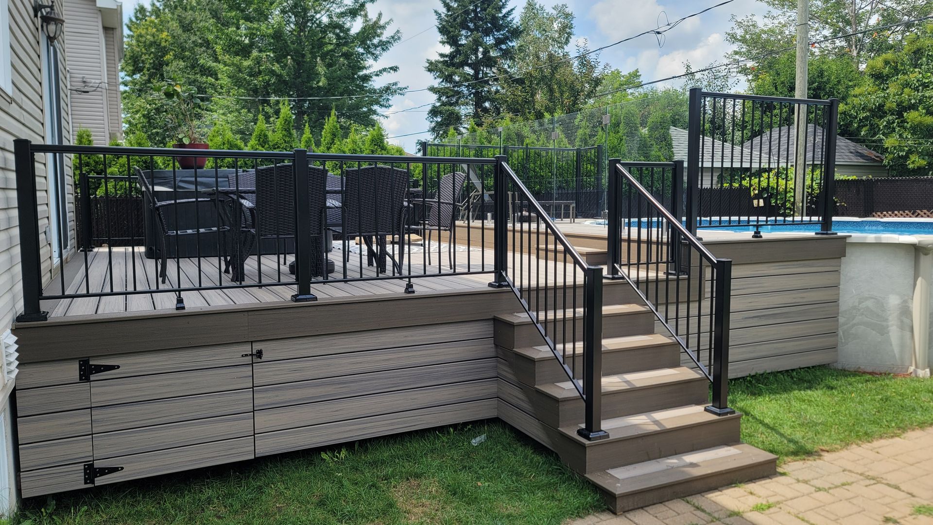 Une terrasse avec des escaliers qui y mènent et une piscine en arrière-plan.