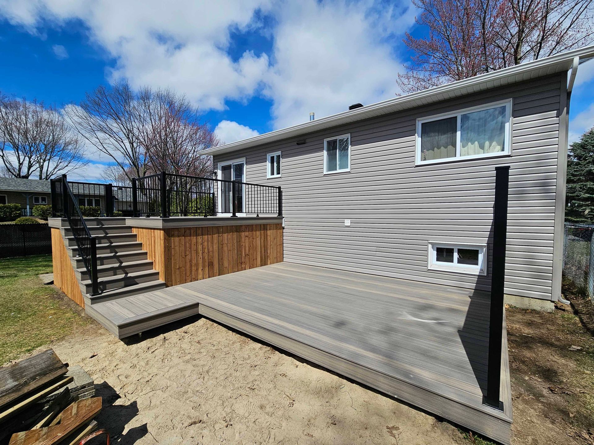 Une maison avec une grande terrasse et des escaliers devant.