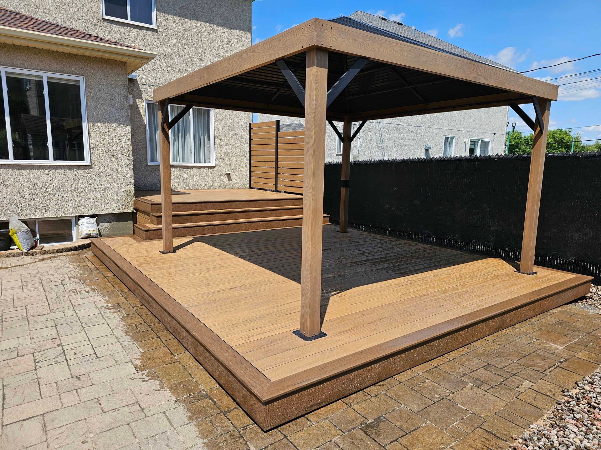 Une terrasse avec un gazebo dans l'arrière-cour d'une maison.