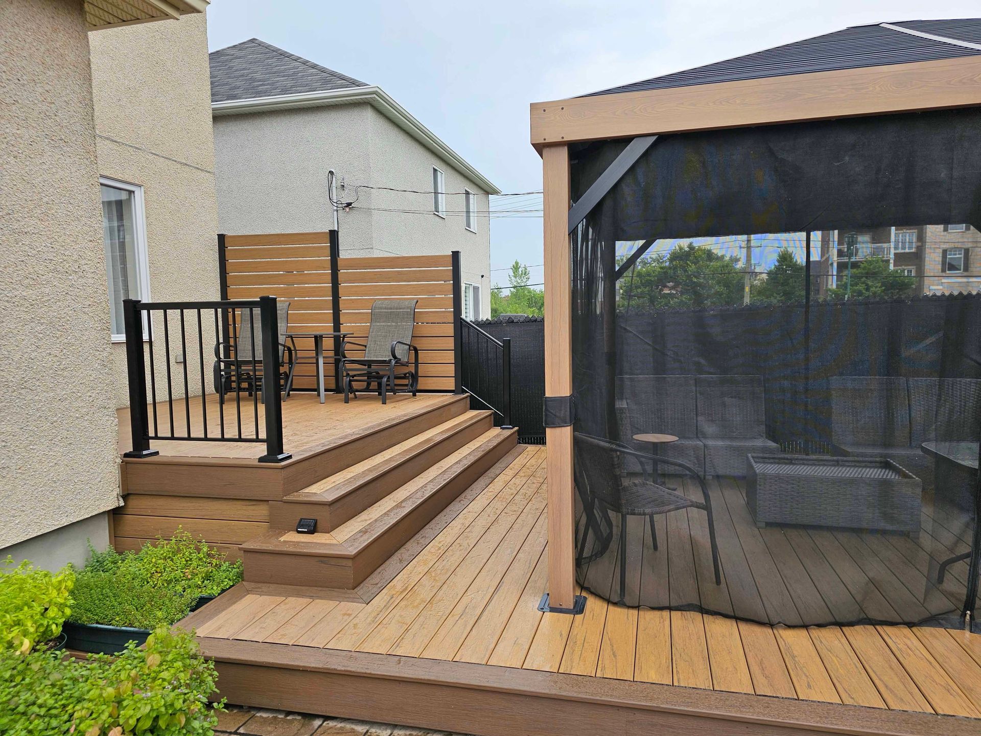 Une terrasse avec un gazebo et des chaises dessus.