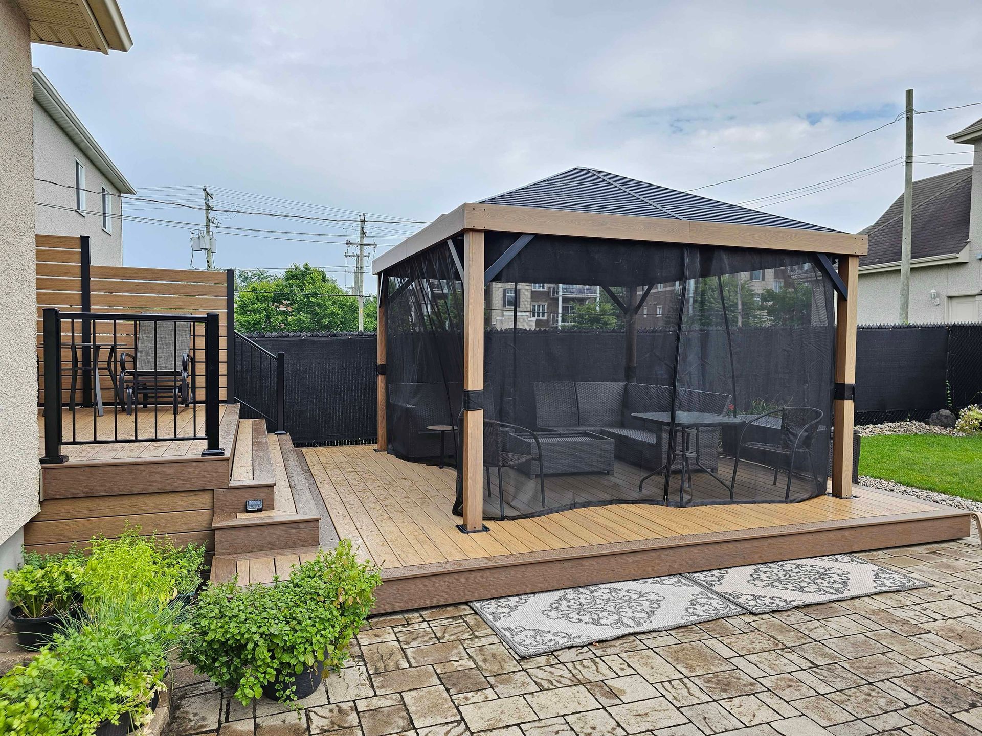 Un gazebo avec une moustiquaire se trouve dans l'arrière-cour d'une maison.
