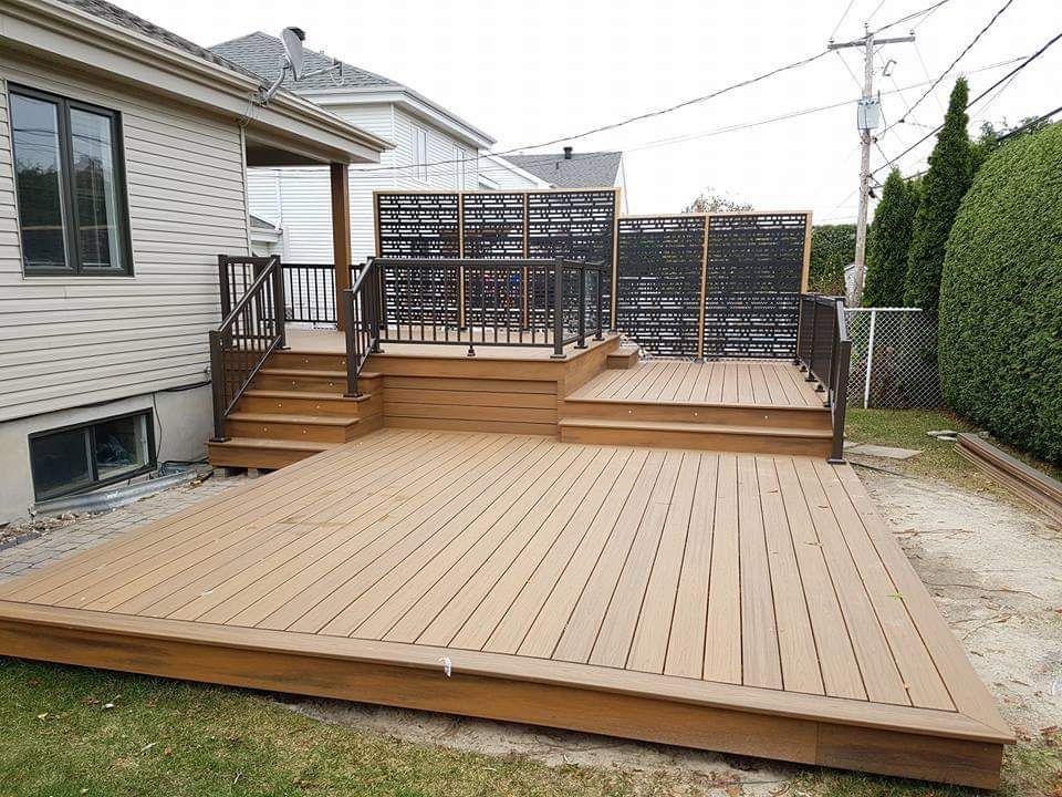 Une grande terrasse se trouve dans l'arrière-cour d'une maison.