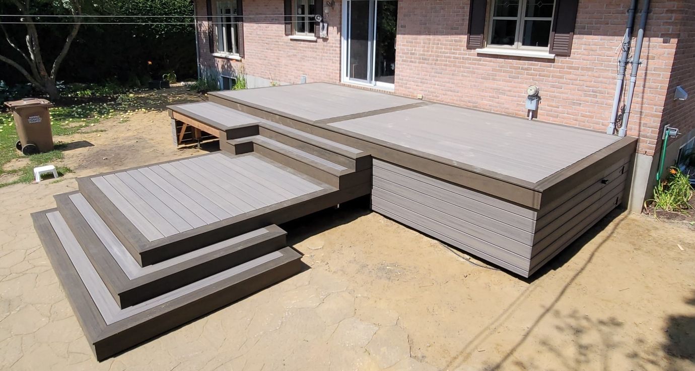 Une terrasse avec des escaliers devant une maison en brique.