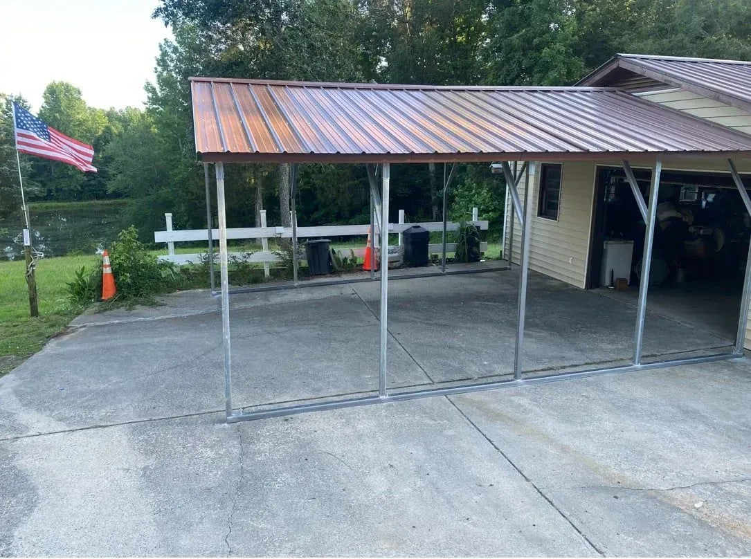 A carport with a metal roof is in front of a house.