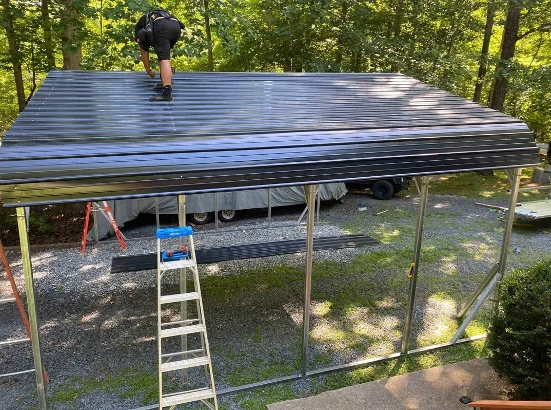 A man is standing on top of a metal roof.