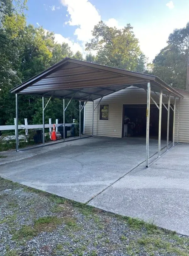A carport is sitting in front of a house.