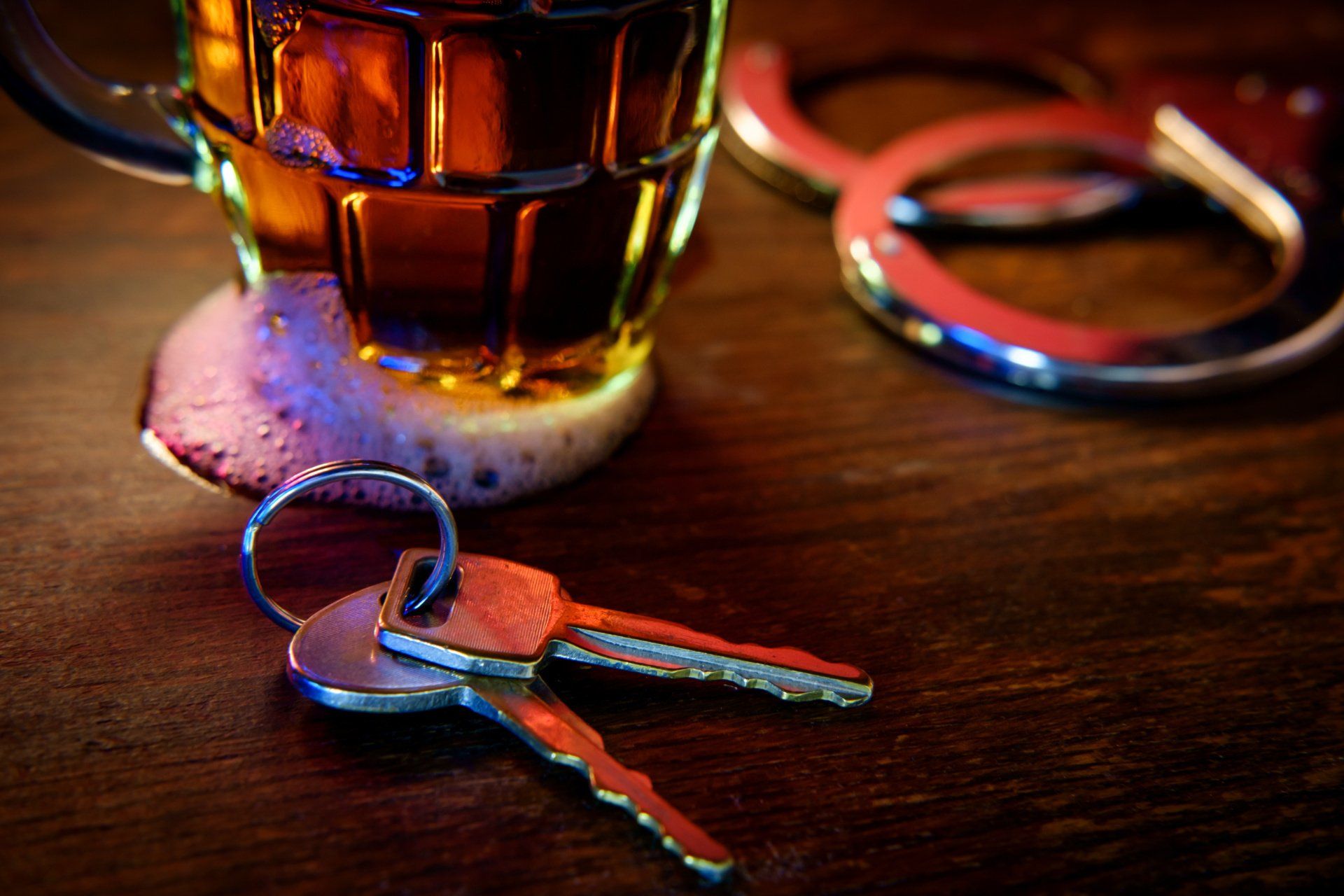 alcohol, keys and handcuffs on a table