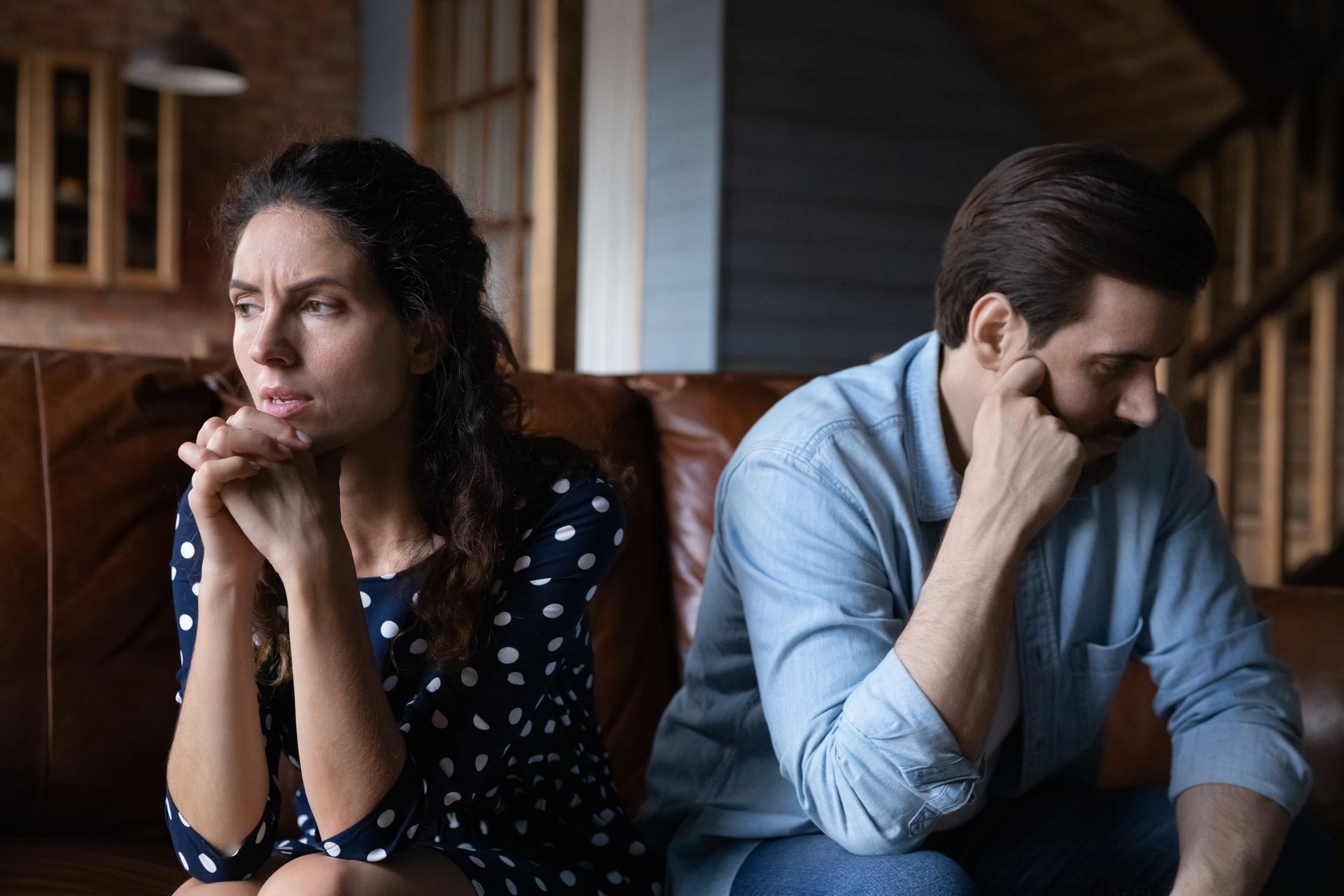 married couple sitting on a couch looking away