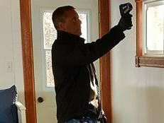 A man is taking a picture of a window with a camera.