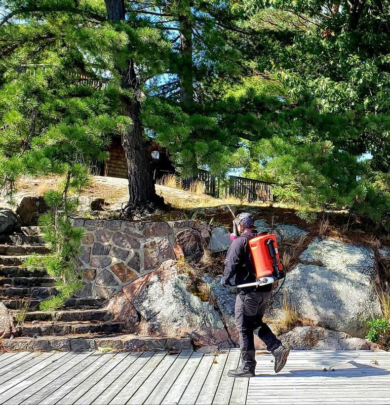 A man with a red backpack is walking on a wooden deck.