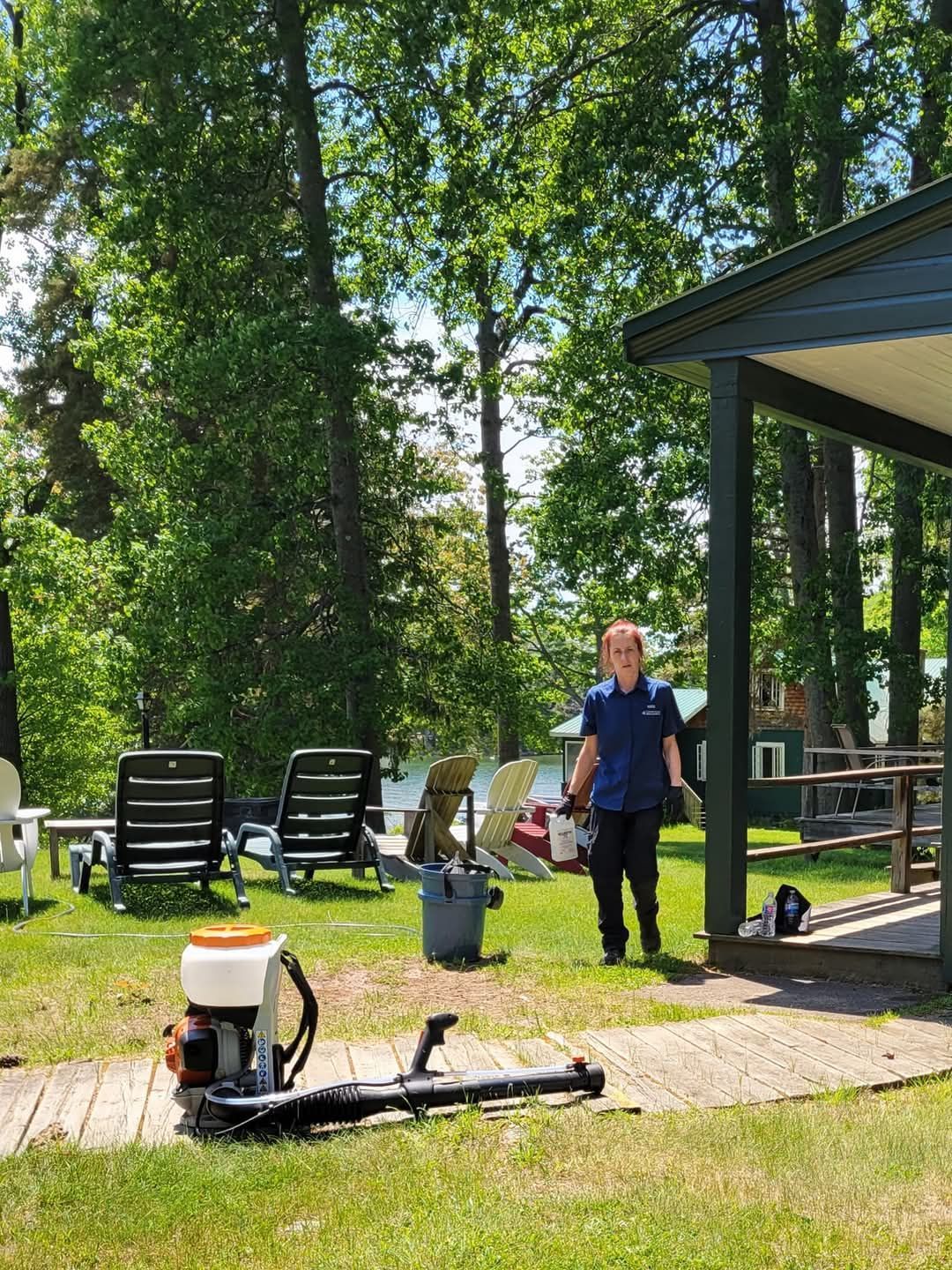 A man is standing next to a lawn mower in a yard.