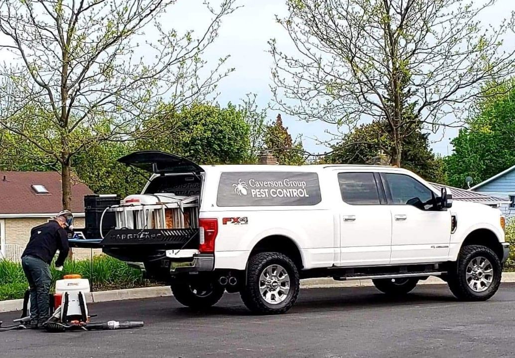 A man is working on the back of a white truck.
