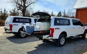 Two white trucks are parked next to each other in a parking lot.