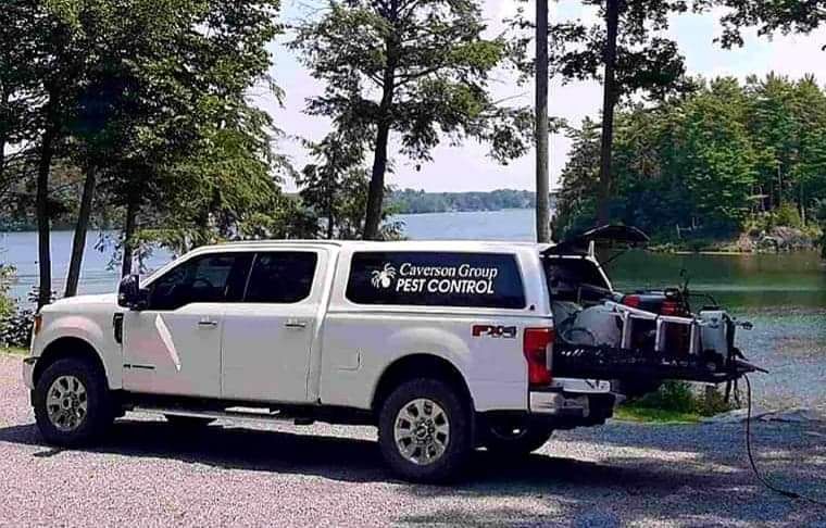 A white truck is parked next to a lake.