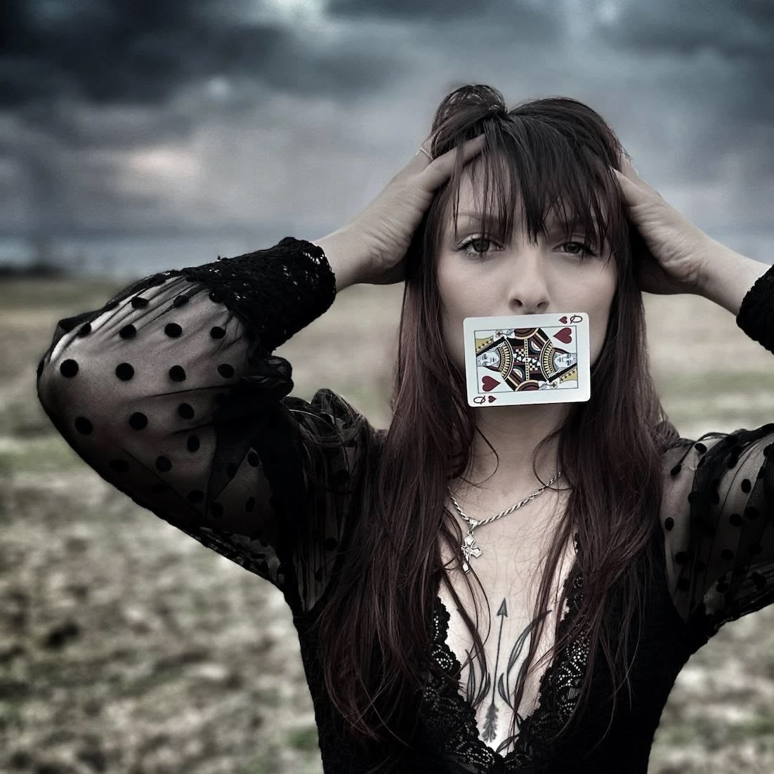 A young man is sitting on a bale of hay.