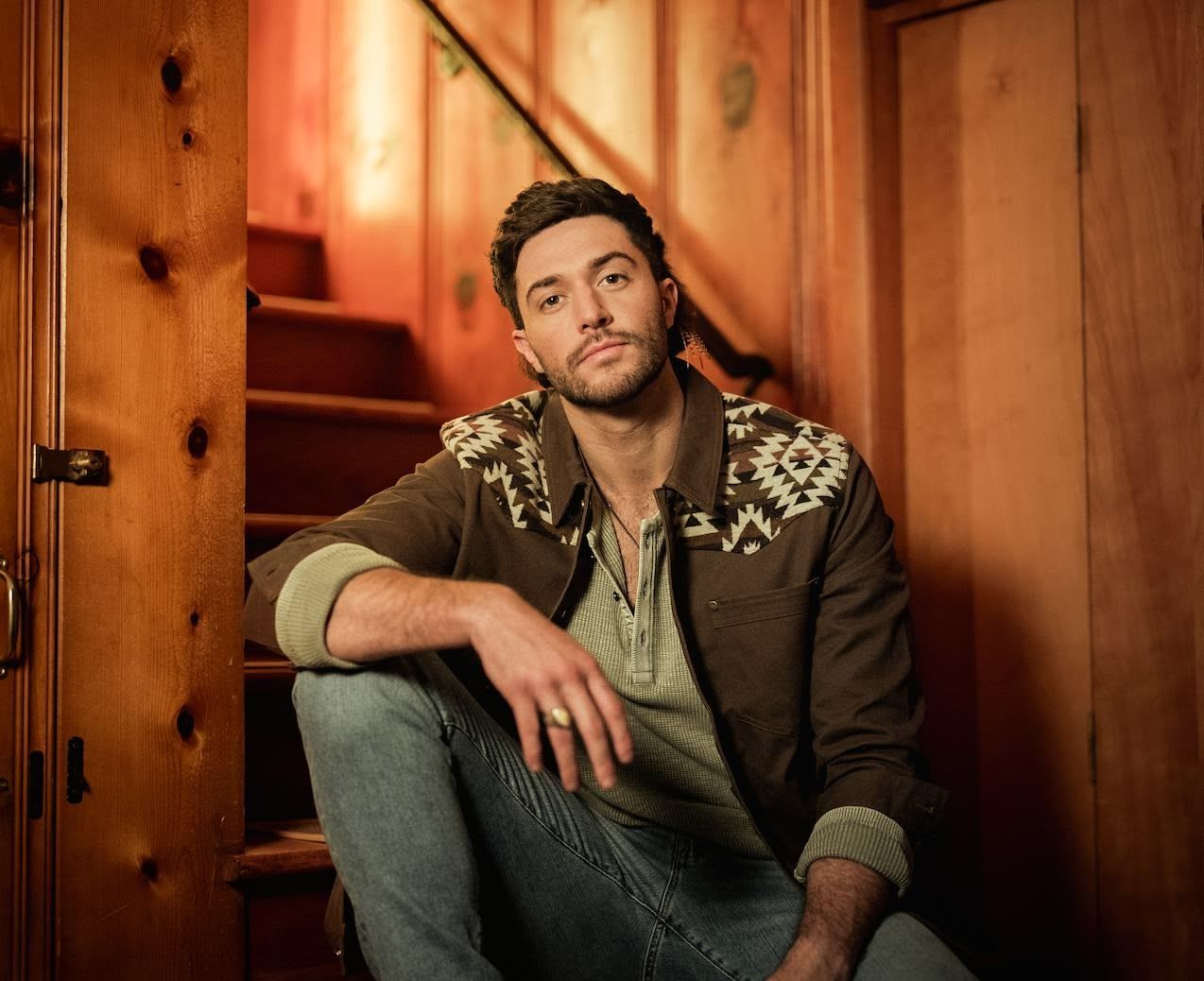 A man is sitting on the floor in a black and white photo.