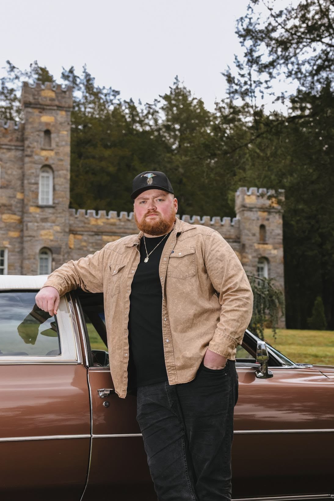 A black and white photo of a young man wearing a daytona hat