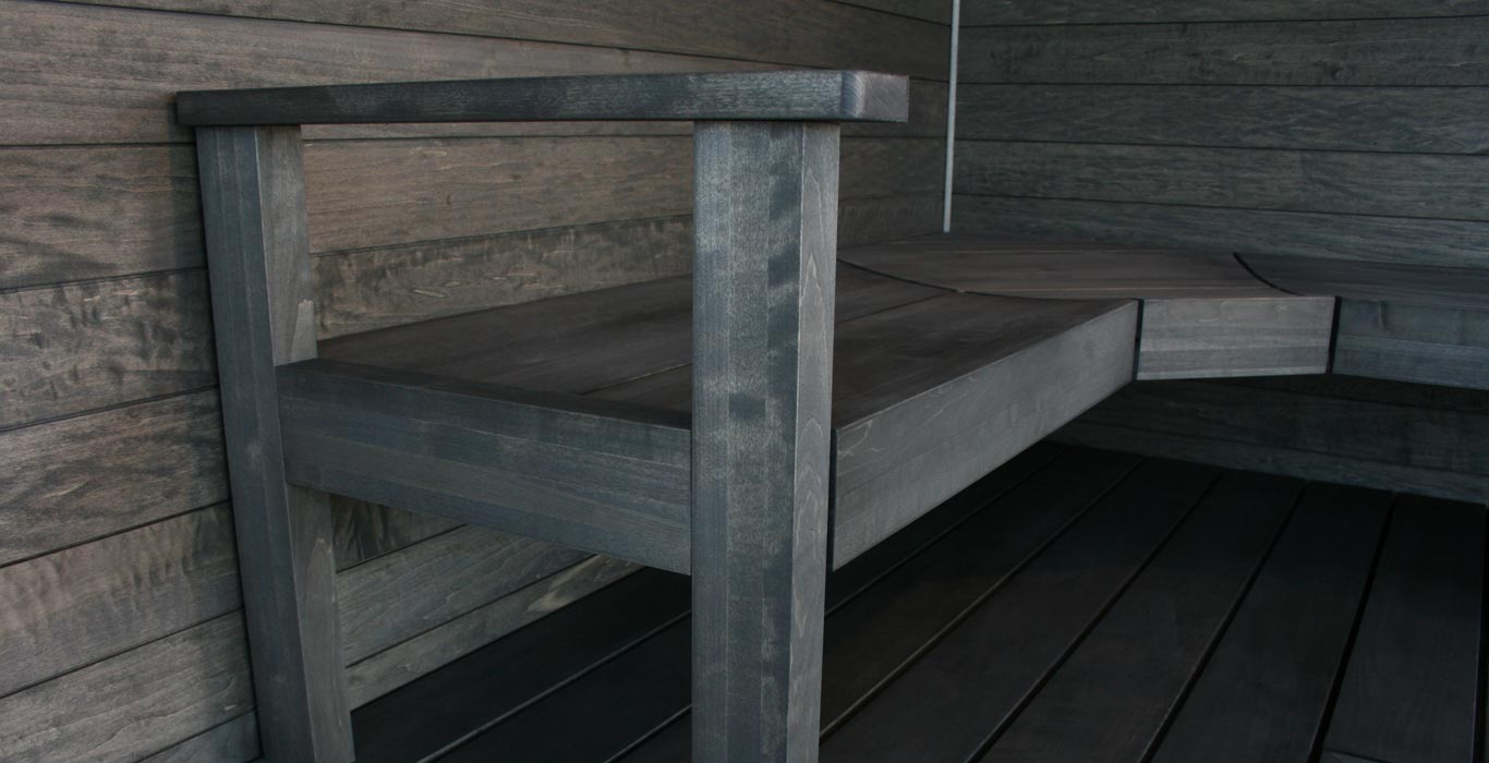a wooden bench is sitting on a wooden deck next to a wooden wall .