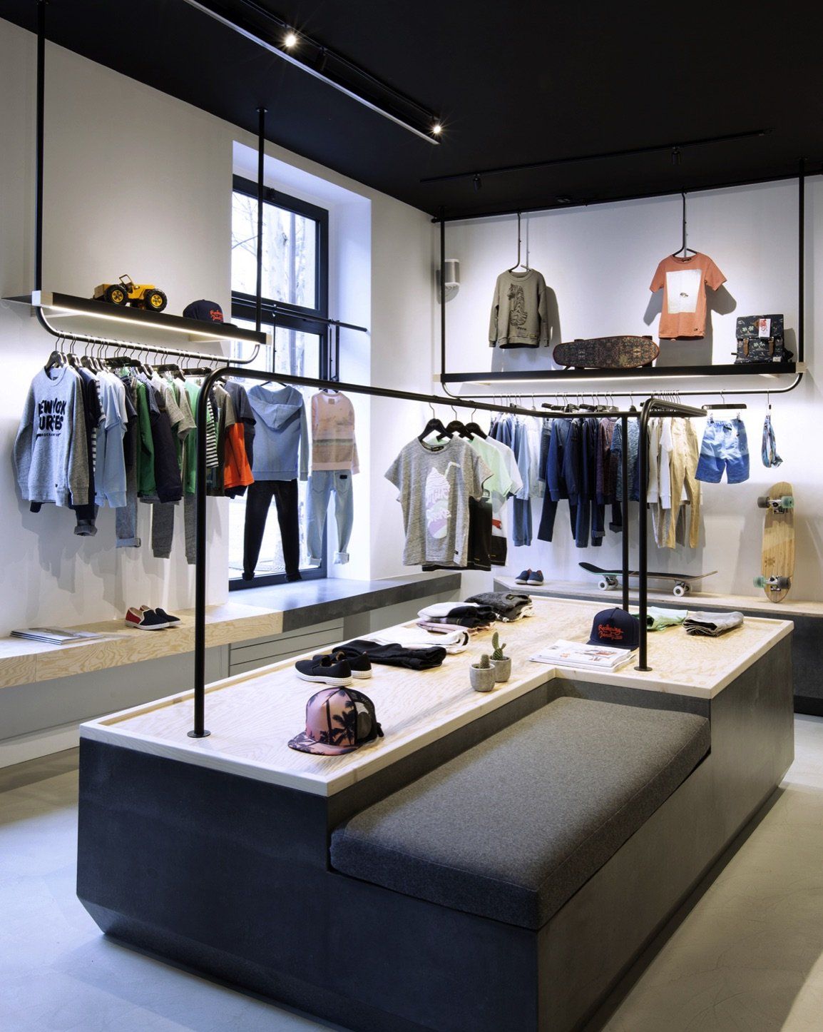 a clothing store with clothes hanging on racks and a table