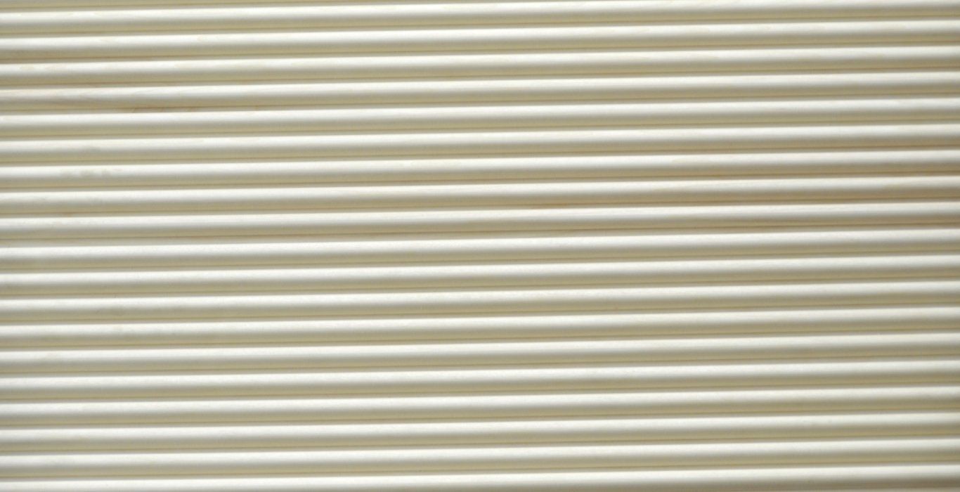 a close up of a white corrugated metal wall .
