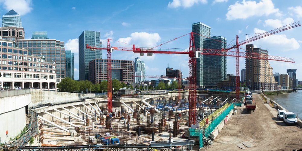 a large construction site with cranes and buildings in the background .
