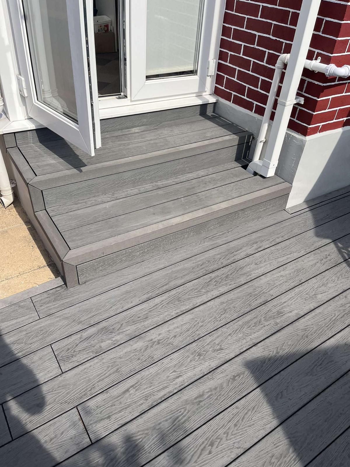 a wooden deck with stairs leading up to a door .