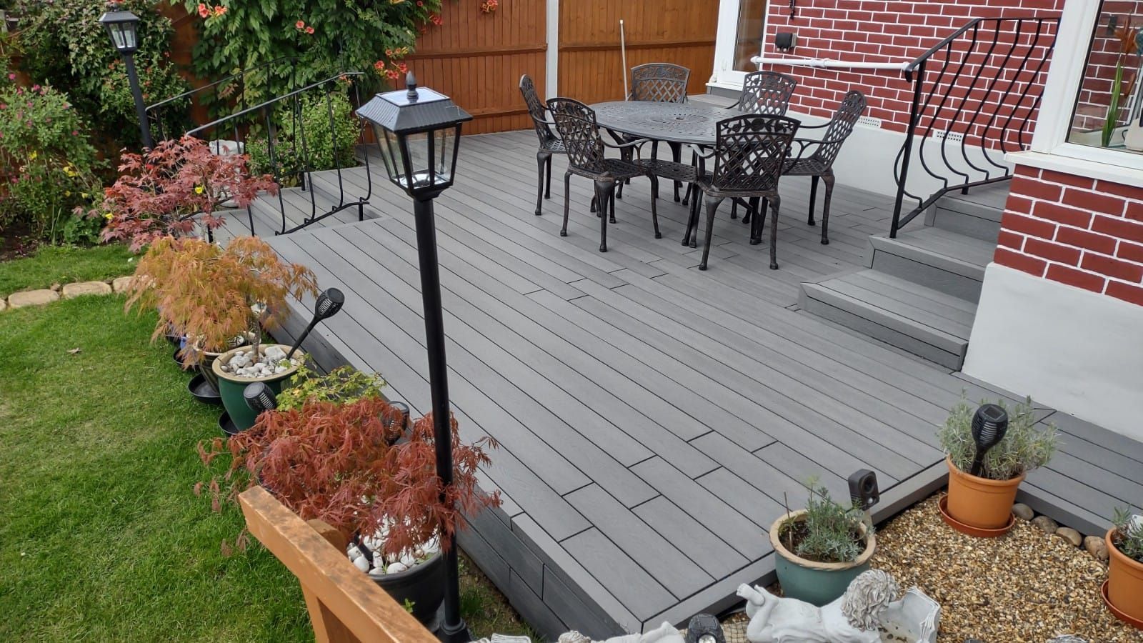 a patio with a table and chairs in front of a brick house .