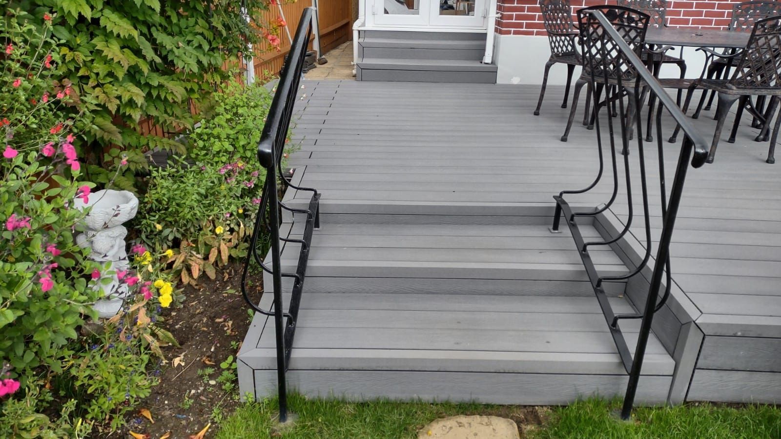 a deck with stairs leading up to it and a table and chairs on it .