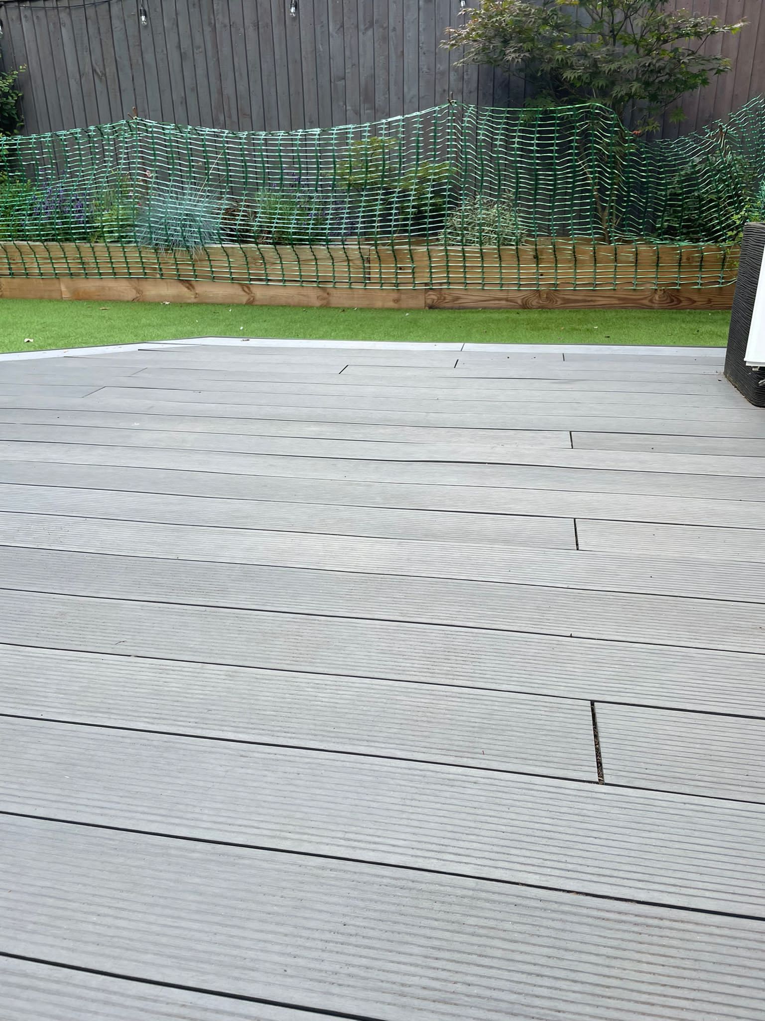 a gray tile floor with a fence in the background