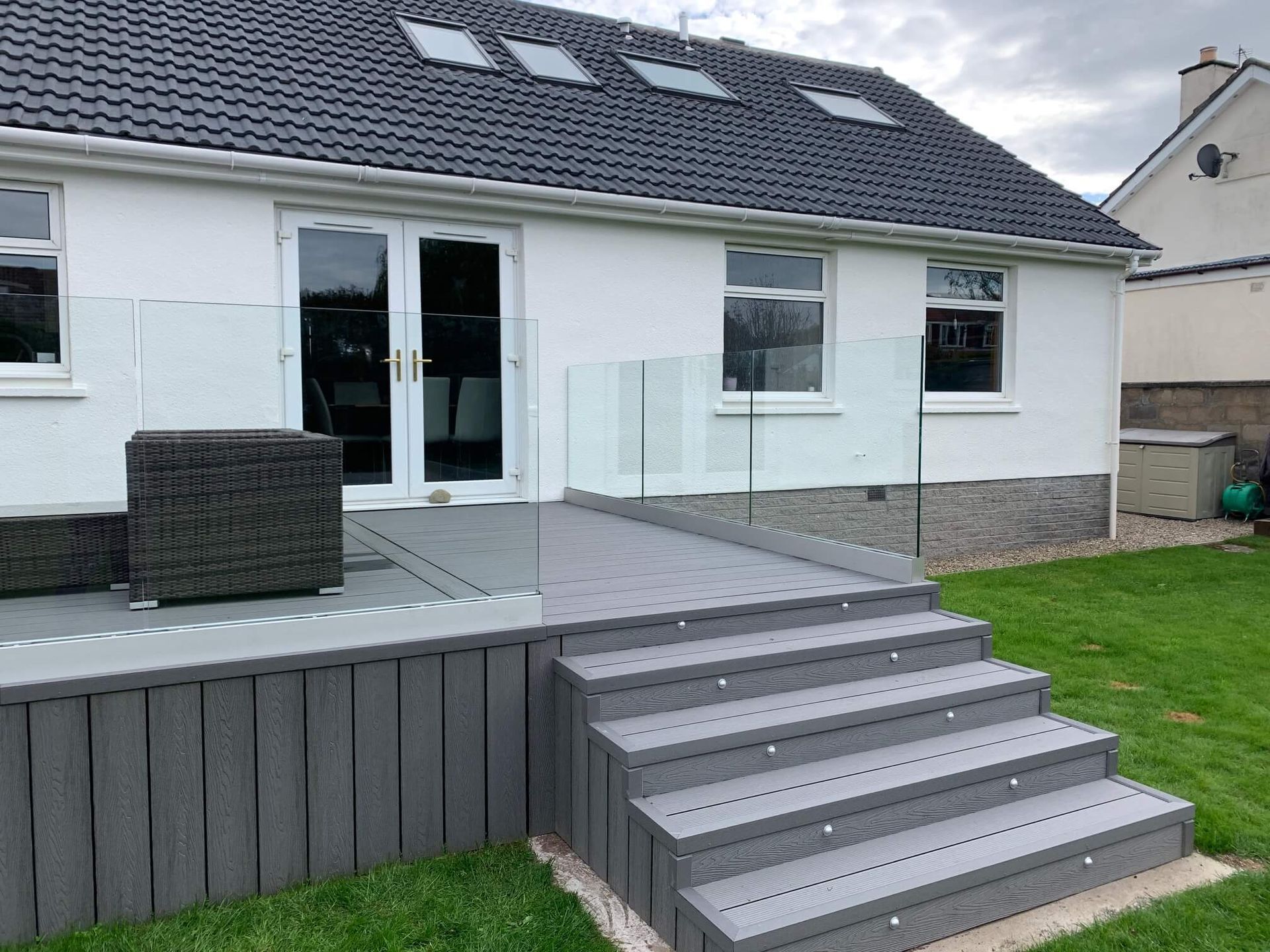 a white house with a deck and stairs in front of it .