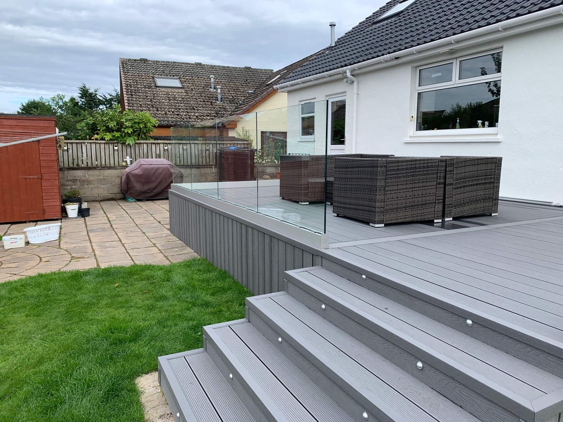 a house with a deck and stairs in front of it .
