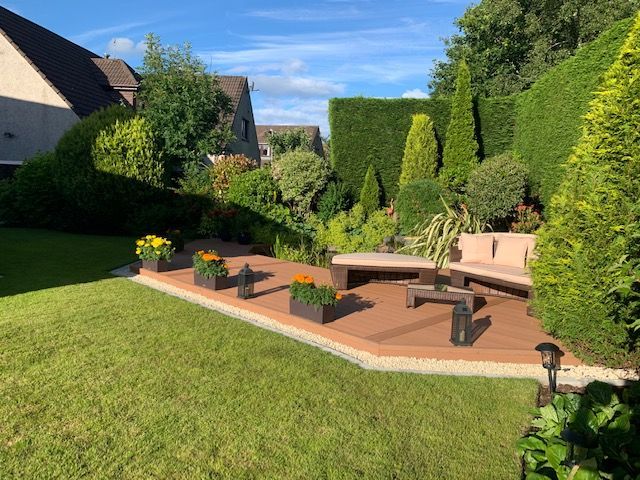 a garden with a wooden deck and a couch