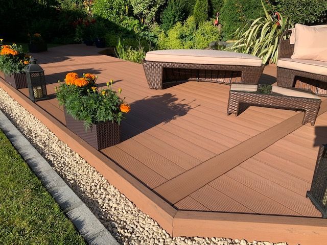a wooden deck with furniture and planters on it