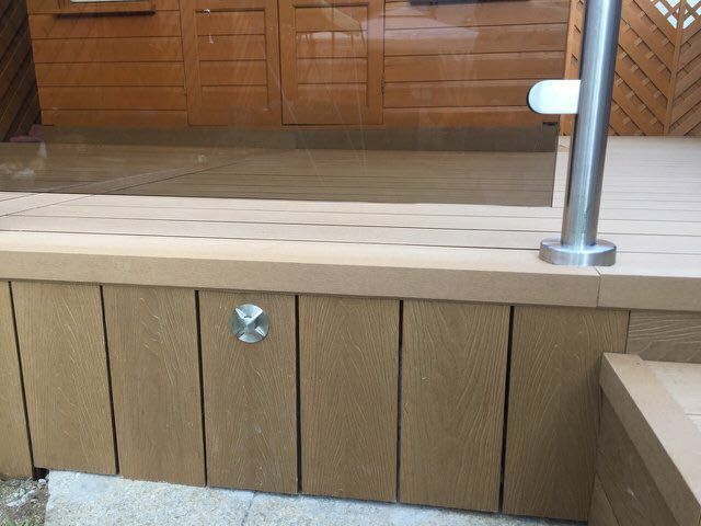 a wooden deck with a stainless steel railing