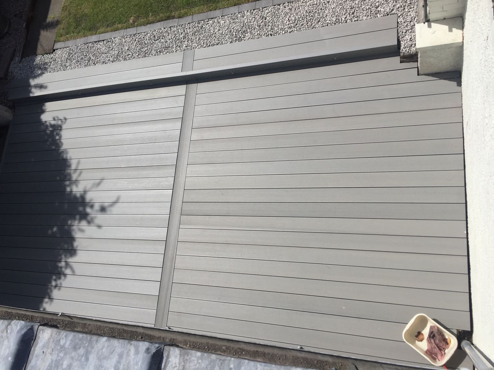 a gray wooden deck with a bucket of food on it .