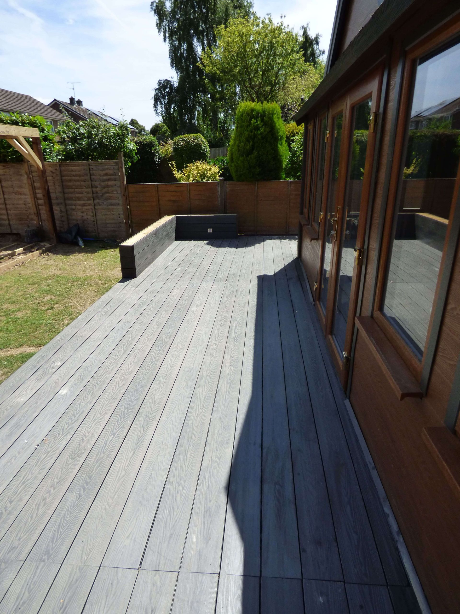 a wooden deck with a house in the background
