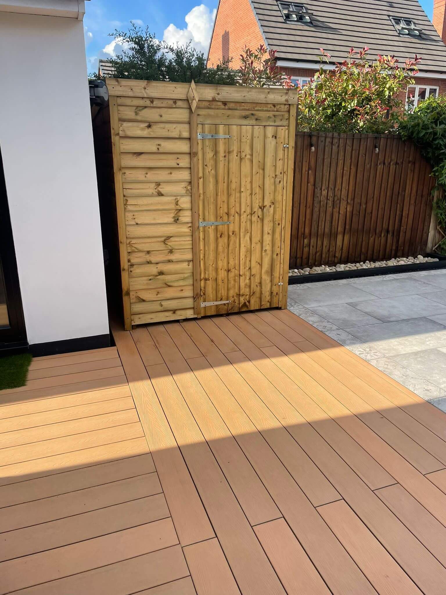 a wooden shed with a fence in the background