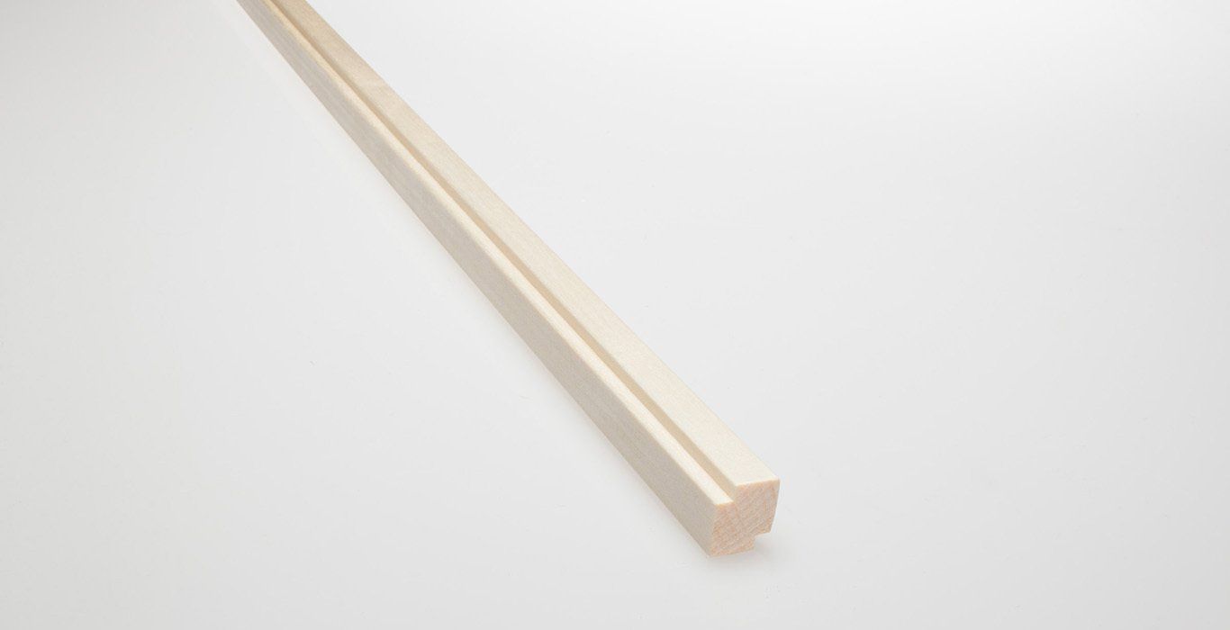 a long piece of wood is sitting on a white surface .
