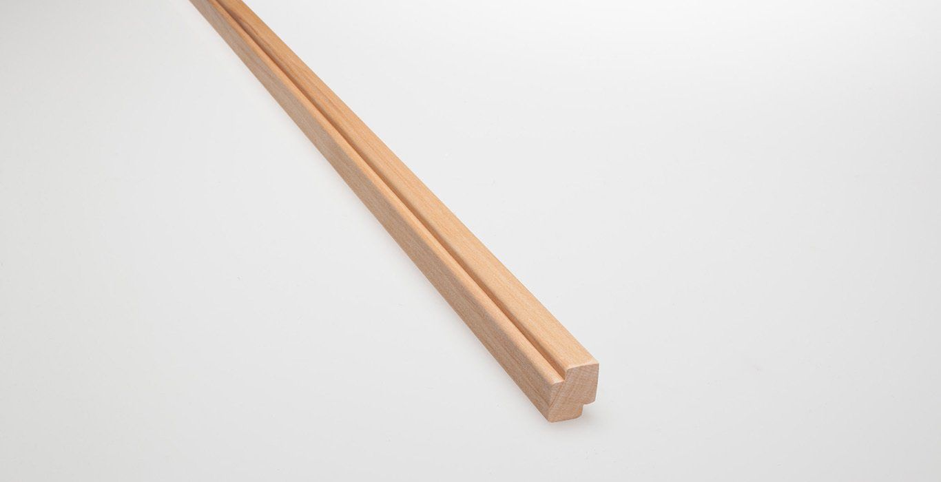 a long piece of wood is sitting on a white surface .