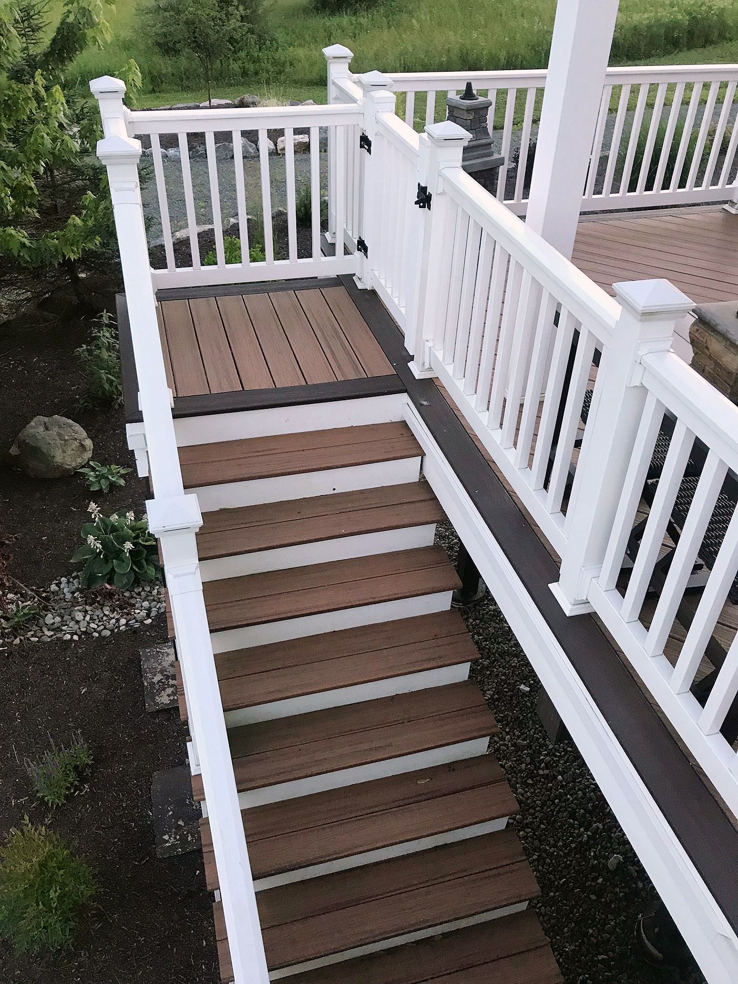 A wooden deck with stairs and a white railing.