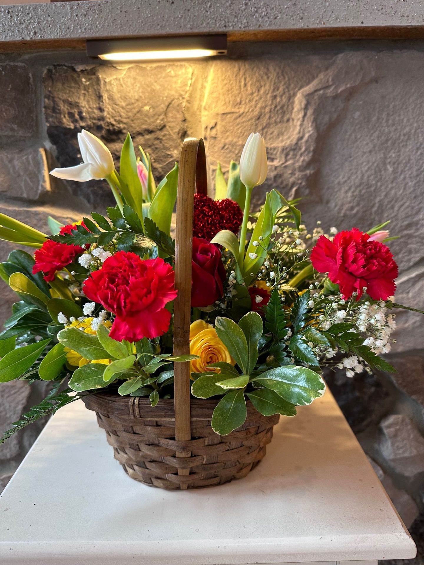 A basket filled with flowers is sitting on a table.