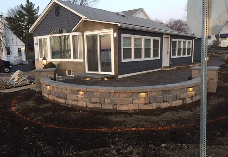 A house with a brick wall in front of it