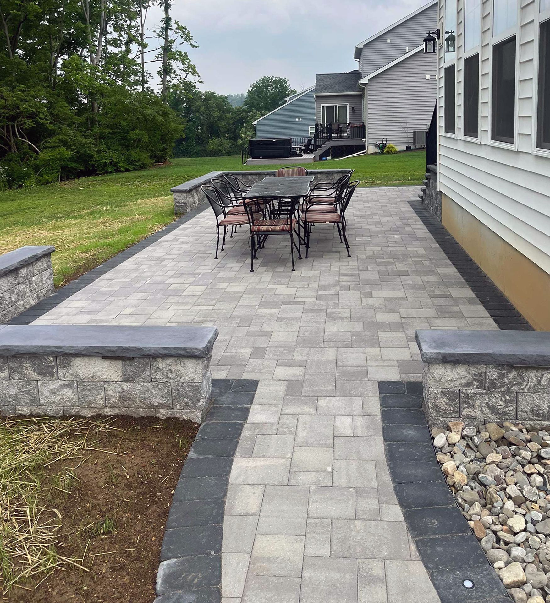 A patio with a table and chairs in front of a house