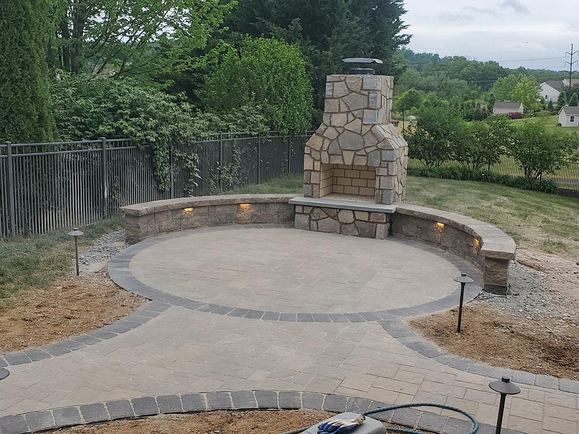 A stone fireplace sits in the middle of a patio