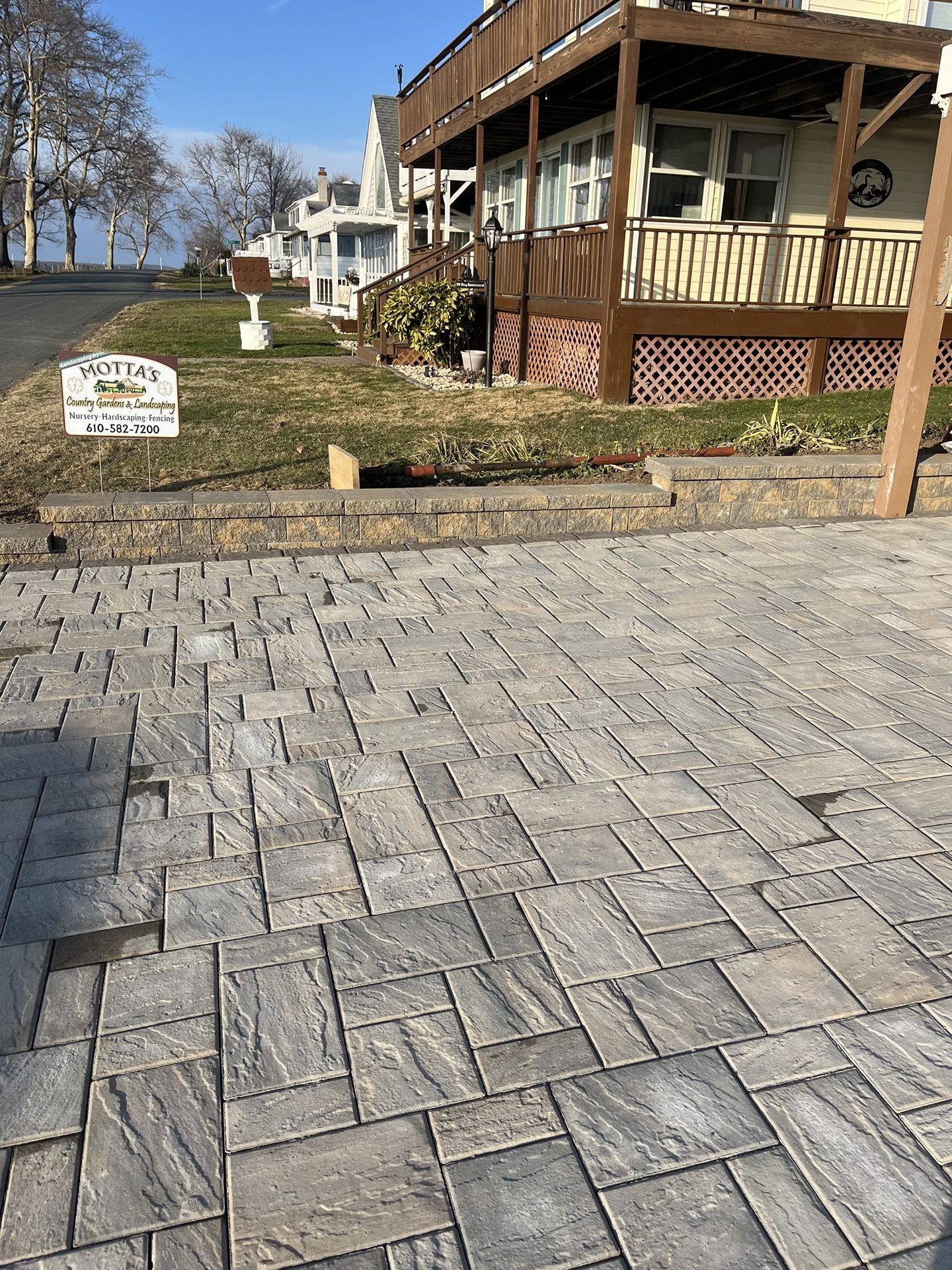A brick driveway is being built in front of a house.
