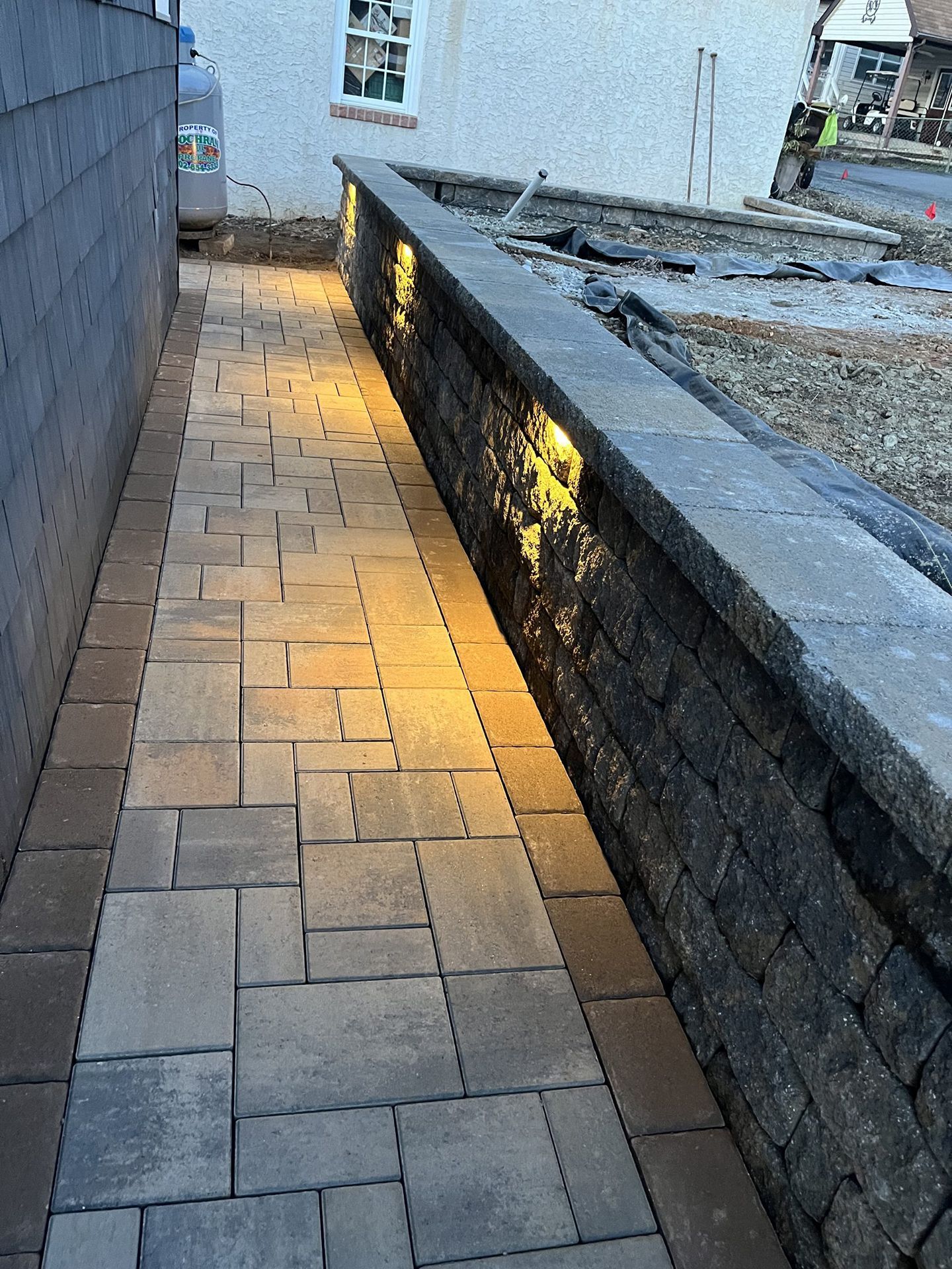 A walkway with lights on the side of it leading to a building.