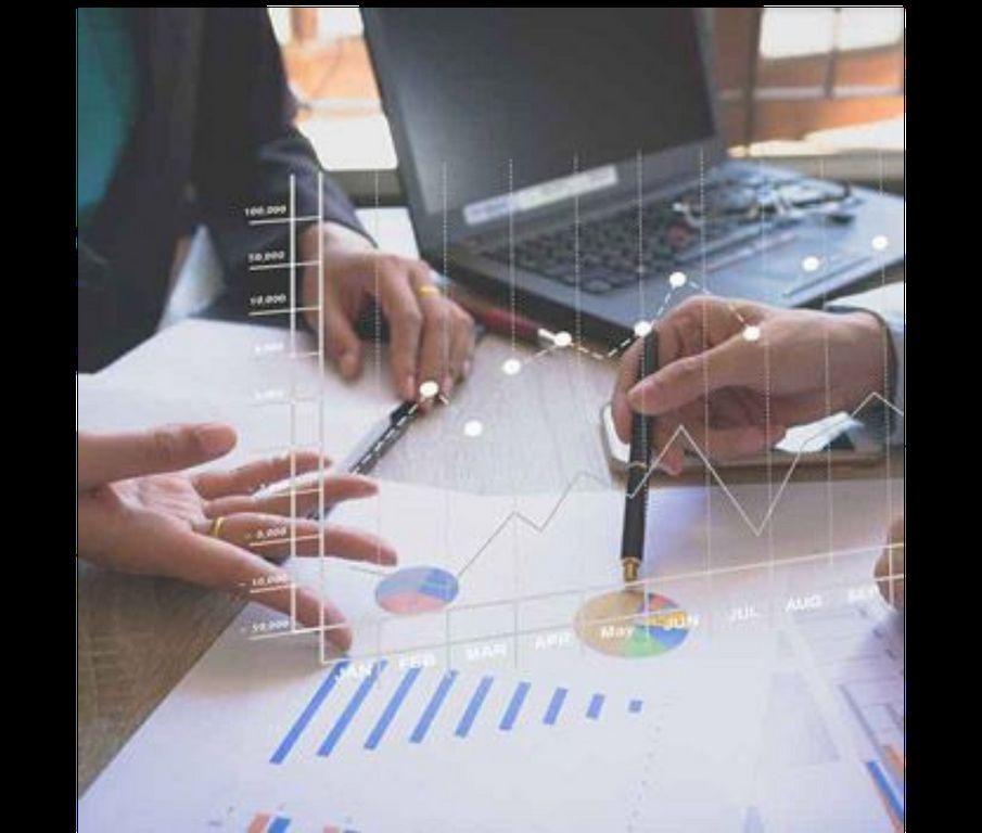A group of people are sitting at a table looking at graphs and charts.