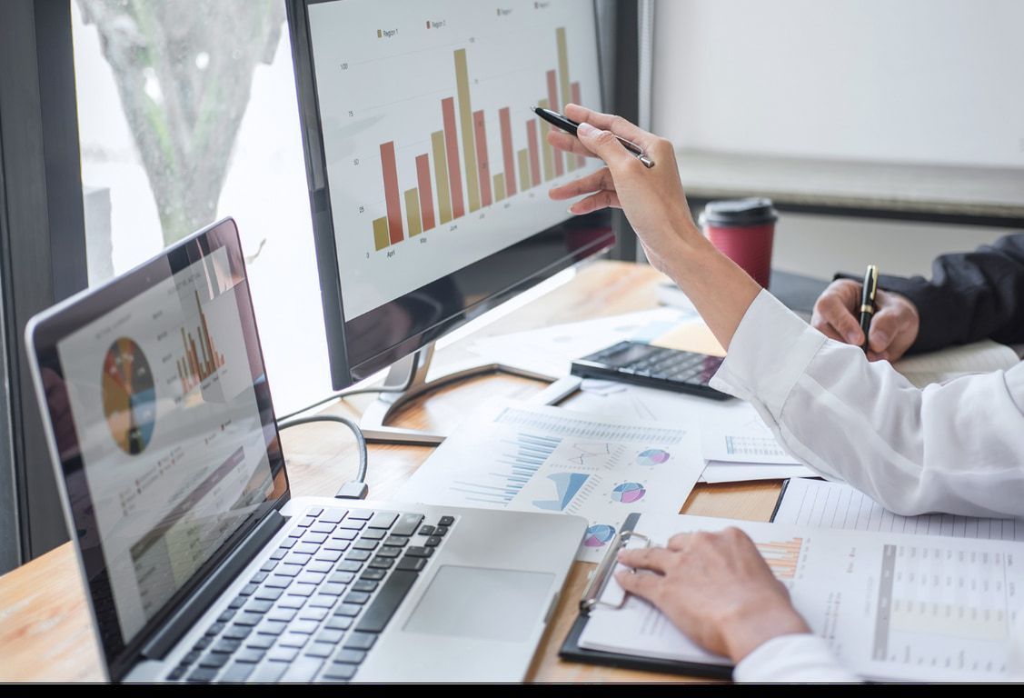 A person is pointing at a graph on a computer screen.