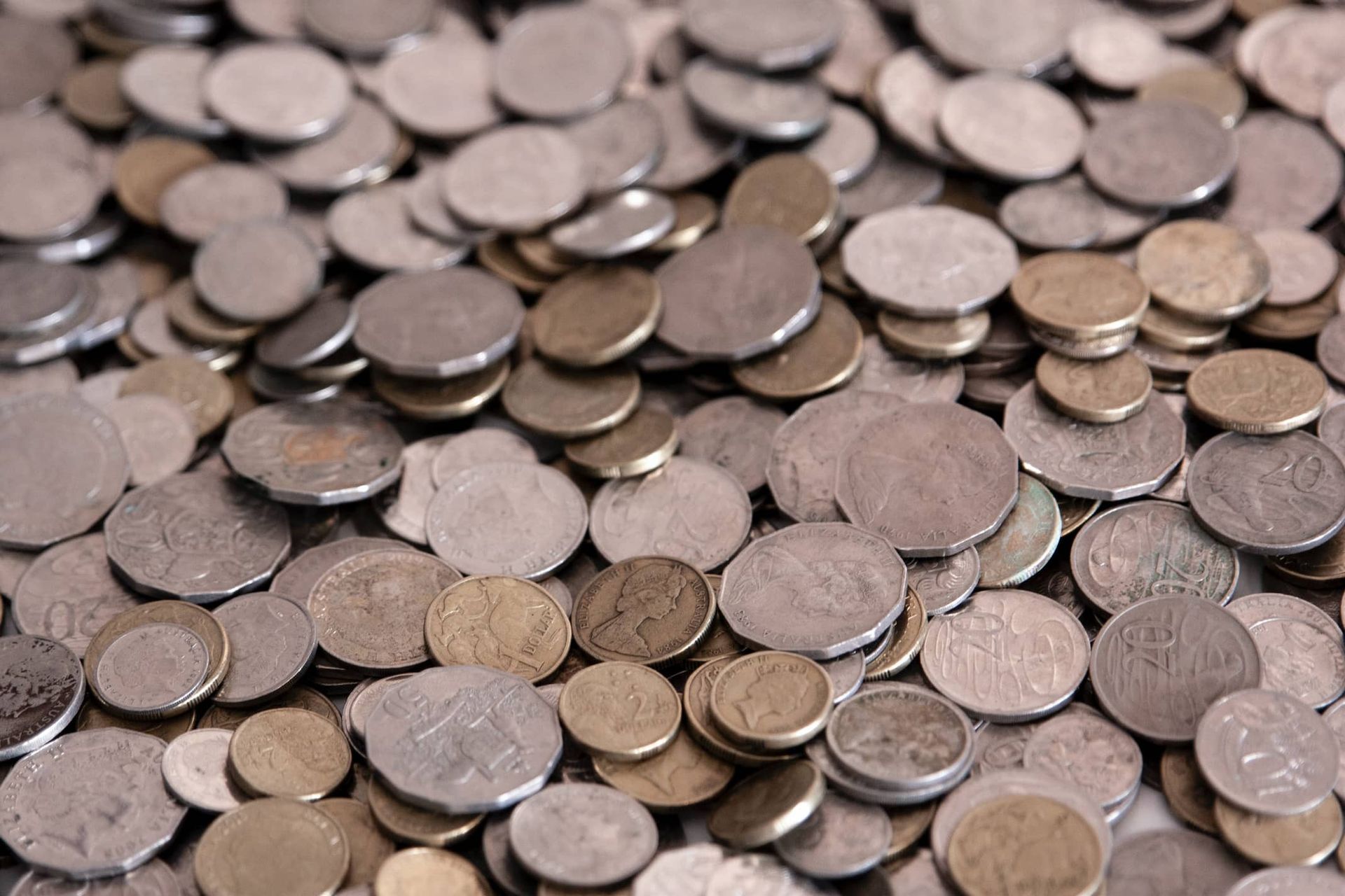 A pile of silver and gold coins with one that says 20 on it